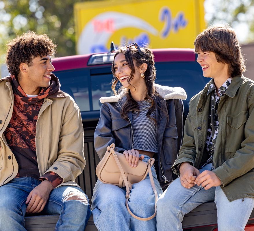 3 friends sitting on back of truck